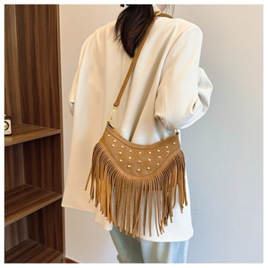 Vue arrière du mannequin portant un sac demi-lune en daim marron avec rivets et franges