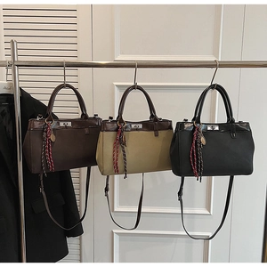 Three matte retro handbags in brown, green, and black with metallic twist locks and tassels
