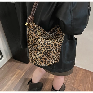 Retro leopard print bucket bag with brown leather strap and gold charm detail