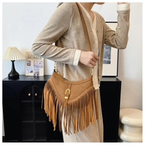 Détail du sac bandoulière vintage en daim marron avec franges denses et crochets dorés