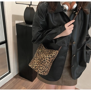 Close-up of leopard print bucket bag with vintage metal buckle and chain strap detail