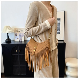 Détail du sac hobo en daim caramel avec de longues franges et une boucle dorée
