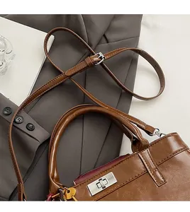 Vue détaillée du sac bandoulière marron avec fermoir argenté et bandoulière réglable