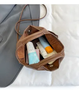 Spacious interior of brown bucket bag showing large capacity for cosmetics and phone