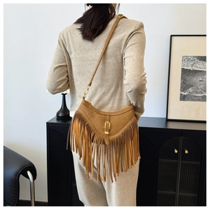 Détail du sac croissant en daim marron bohème avec longues franges et boucle