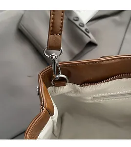 Détail du sac à main en cuir marron avec crochets amovibles argentés et poche intérieure zippée