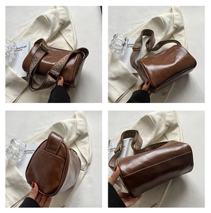 Vue détaillée du sac polochon marron avec sa bandoulière tissée colorée élégante