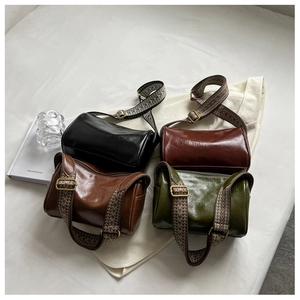 Retro barrel bags in four colors with ethnic woven straps on a minimalist bed setting