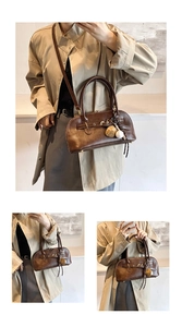 Detail view of vintage dark brown shell bag with retro buckle and baseball glove charm