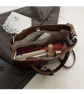 Intérieur spacieux d'un sac cabas en cuir vintage marron avec objets du quotidien