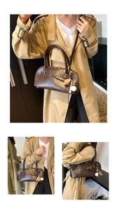 Detail view of the vintage dark brown shell bag with hardware buckles and charm