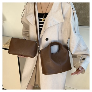 Detail view of brown lychee grain leather handbag set with matching zipper pouch and strap
