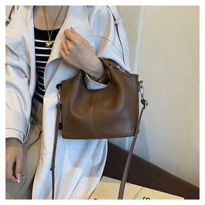 Detail of dark brown lychee grain leather handbag with silver hardware and shoulder strap