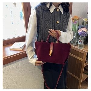 Détail du sac cabas en daim bordeaux avec fermoir ovale doré et doubles poignées chic