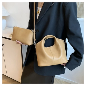 Close-up of khaki lychee grain bucket bag and matching pouch with detailed leather texture