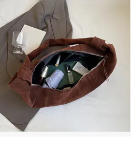 Detailed view of dark brown suede bag interior showing large capacity and zipper closure