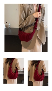 Detail of dark red crescent bag with pleated suede finish and knotted shoulder strap