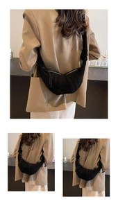 Detail of black faux suede crescent bag showing knot strap and metal zipper closure
