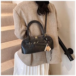 Rear view of model wearing a retro dark grey shell bag with textured matte finish