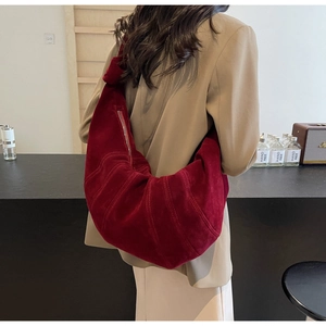 Detail of burgundy suede croissant bag with vertical stitching and metal zipper