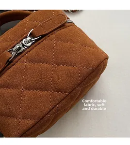 Detail of brown quilted suede fabric and premium dual silver metal zippers on crossbody bag