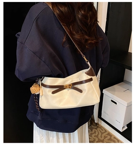 Close-up of PU leather shoulder bag with metal turn-lock and cute bread charm detail