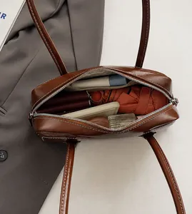 Top view of brown leather bag showing large capacity with phone, umbrella and cosmetics