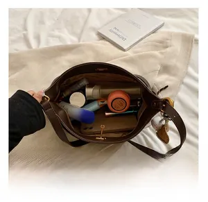 Spacious interior of a brown PU leather shoulder bag with daily items and logo lining