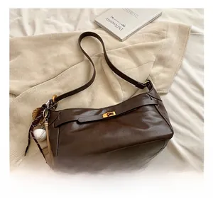 Close-up of brown PU leather shoulder bag with gold clasp and baseball charm details