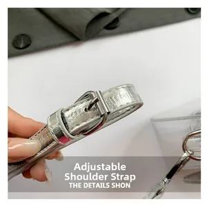 Close-up of adjustable silver shoulder strap with metallic buckle on a small square bag