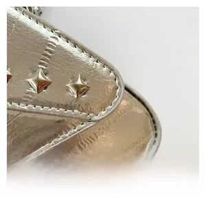 Detail of silver metallic wrinkled fabric with pyramid studs and precision stitching