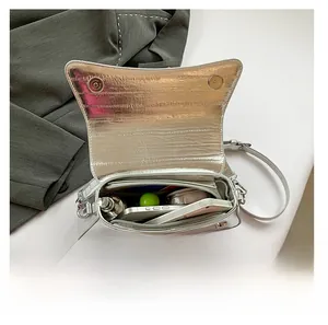 Interior view showing capacity for smartphone and cosmetics in silver crossbody bag