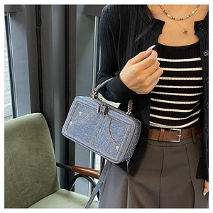 Details der blauen Denim-Schultertasche mit Jeansnähten und goldenen Reißverschlüssen