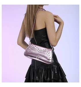 Close-up of pink metallic crossbody bag featuring decorative silver star-shaped rivets