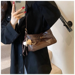 Detail of dark brown PU leather shoulder bag featuring a metal twist lock and heart charms