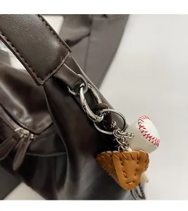 Detailed macro view of dark brown leather handbag with silver rings and baseball charms