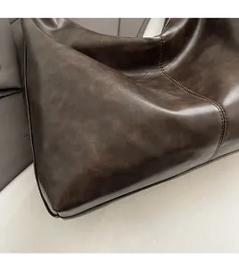 Detailed macro of dark brown vintage leather bag with visible double row stitching