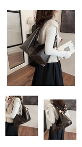 Detail view of large dark brown leather tote bag with wide strap in a home setting