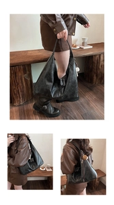 Close-up of vintage dark grey tote bag with wrinkled texture and metal zipper detail