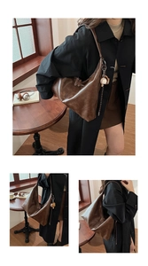 Detailed view of the large capacity retro brown leather tote bag with baseball pendant charm