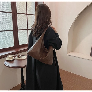 Detail view of a vintage dark brown leather underarm bag with a soft slouchy silhouette
