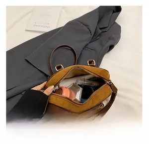 Détail montrant l'intérieur spacieux du sac à main mat marron avec ses essentiels