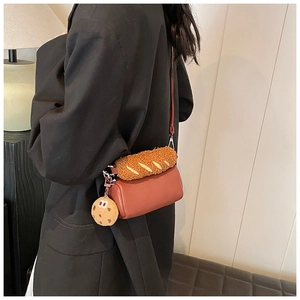 Brown faux leather baguette bag with plush texture and cookie charm shown on shoulder