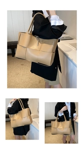 Detail of large beige woven tote bag with premium wide-grid texture and slim straps