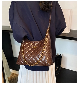 Quilted dark brown hobo bag with gold chain strap shown on a model for scale