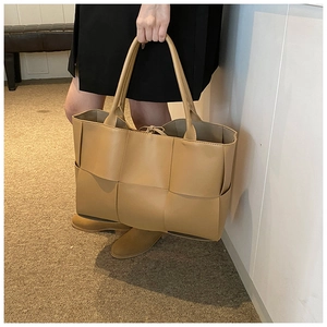 Detailed view of the khaki woven leather tote bag featuring a large capacity design