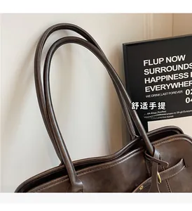 Detail of vintage brown tote bag showing durable slim handles and metal buckle clasp