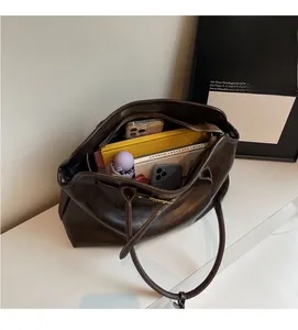 Top view of spacious dark brown tote bag interior with umbrella, phone and books