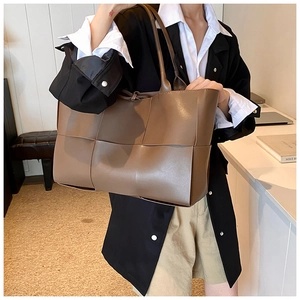 Detail of dark brown woven tote bag with large checkered pattern and slim shoulder straps