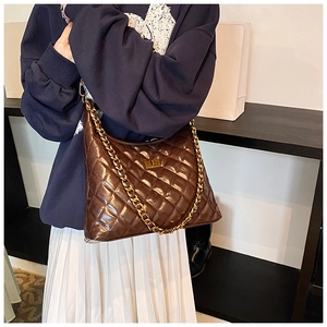 Close-up of brown quilted hobo bag with gold chain strap and turn-lock closure
